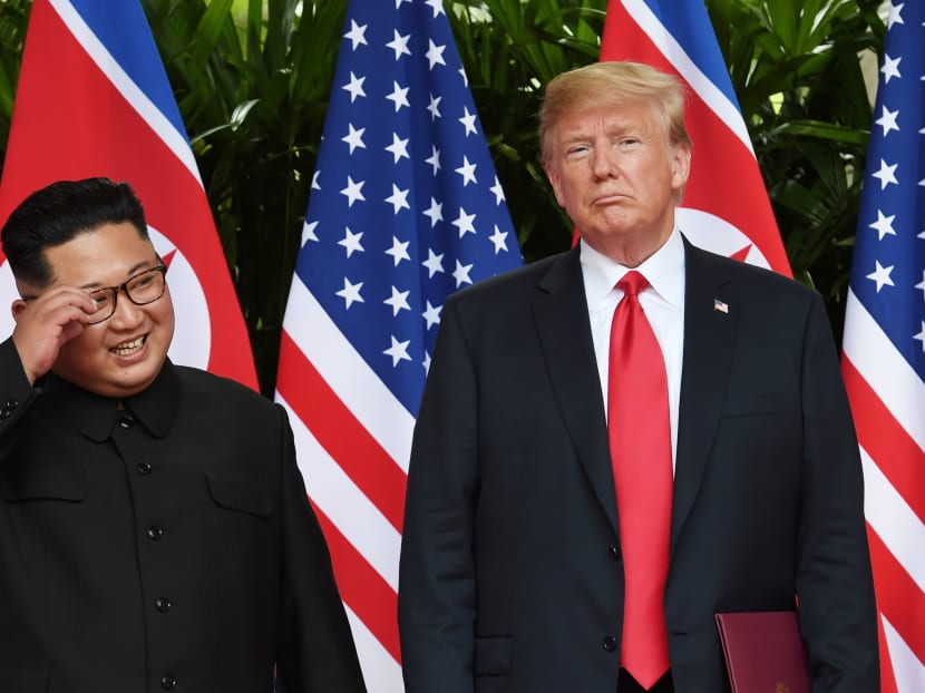 US President Donald Trump and North Korea's leader Kim Jong Un react during their summit at the Capella Hotel on Sentosa island in Singapore June 12, 2018.