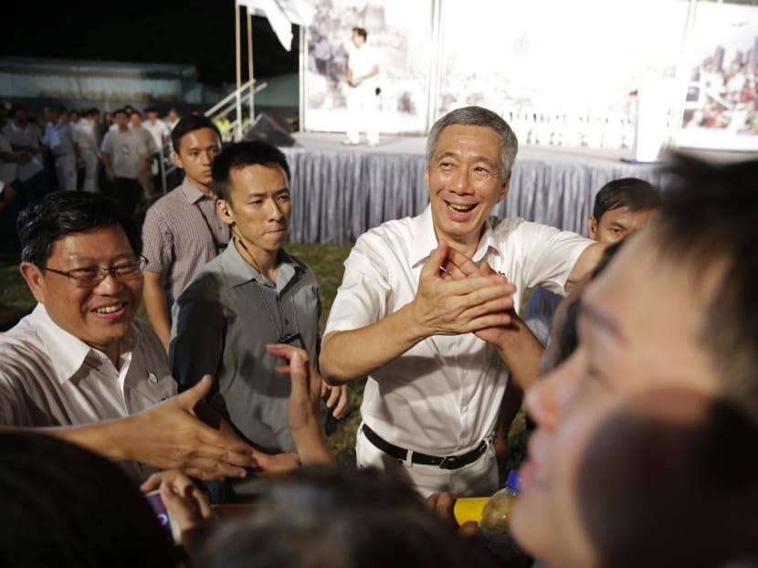 PM Lee, with Mr Yeo Guat Kwang (left) of the PAP Aljunied team and supporters after the rally for 

Aljunied GRC and Hougang SMC yesterday, promised more homes and jobs for the area. Photo: Wee Teck Hian