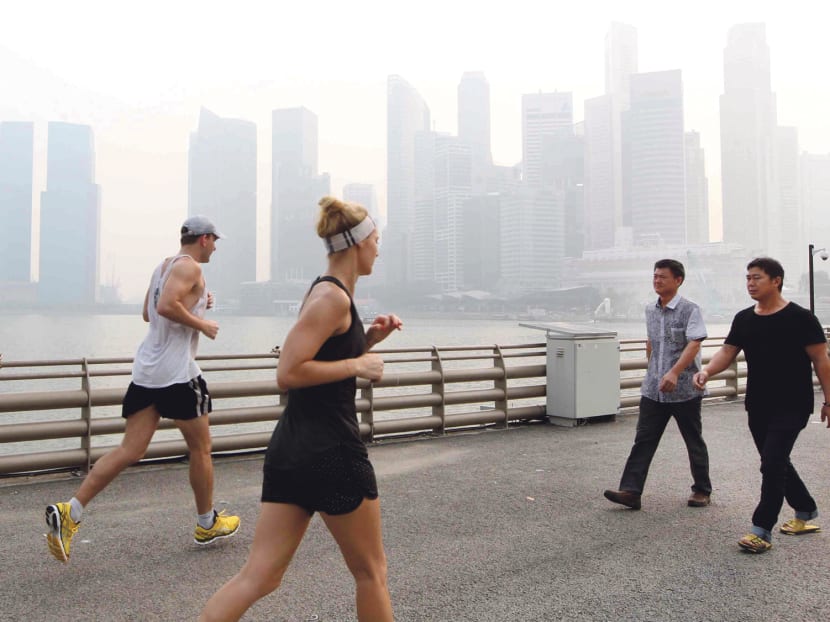 Two runners are out for a run along Marina Bay despite the haze in Singapore at 4.30pm on Oct 6, 2014. Photo: Ooi Boon Keong