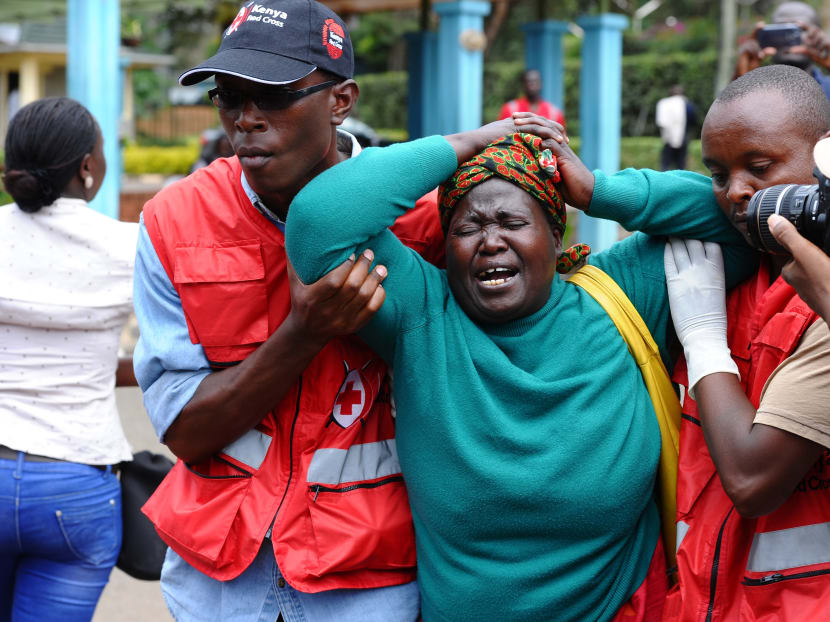Kenya Red Cross staff assist a woman after she viewed the body of a relative killed in Thursday's attack on a university, at Chiromo funeral home, Nairobi, Kenya, Friday, April 3, 2015. Photo: AP