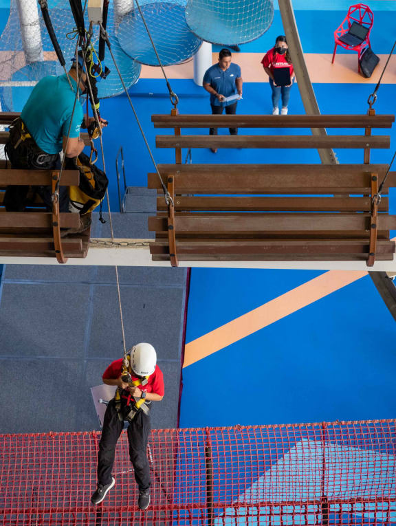An instructor demonstrating the use of an assisted belay device to lower a participant at a training course that followed a set of new guidelines.