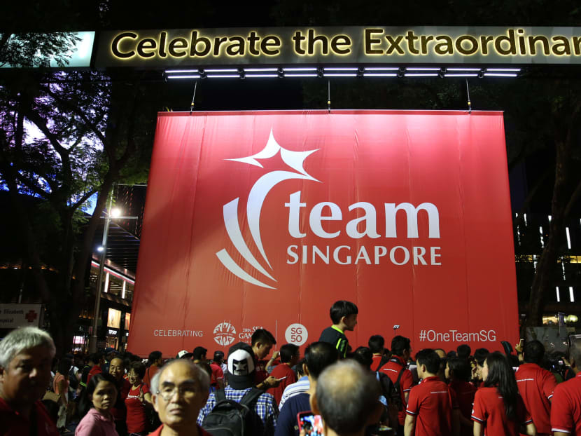 The Team Singapore flag being carried down along Orchard Road and hoisted on the Team Singapore arch during the "One Team Singapore @ Orchard Road" event on March 7. Photo: Wee Teck Hian/TODAY