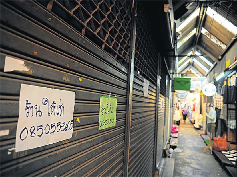 FORCED OUT OF BUSINESS: Many shops in the hard-to-access middle zones of the weekend market are shuttered and display ‘For Lease’ signs. Photo: Bangkok Post