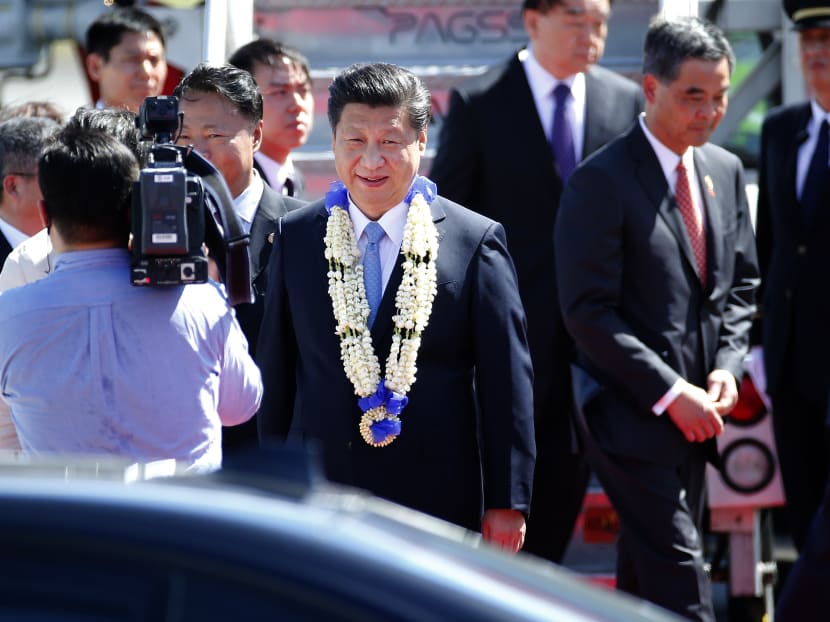 China's President Xi Jinping walks to his car wearing a flower garland gift after his arrival for the the APEC summit in Manila, Philippines Tuesday, Nov 17, 2015. Photo: AP
