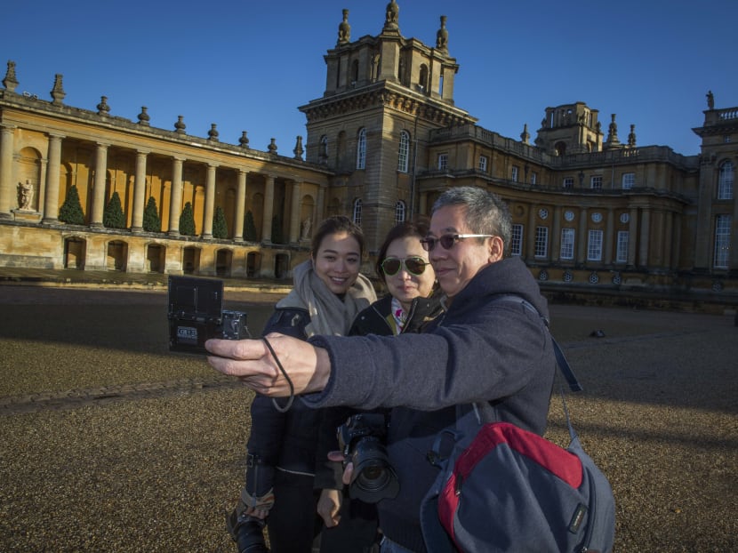 Ms Maria Koo, centre, with her daughter Stephanie Lui and husband, Mr Grandy Lui, tourists from China, take a selfie outside Blenheim Palace in Woodstock, England, Nov 17, 2016. The nearby village of Kidlington has found itself a popular stop for Chinese visitors who snap photographs of their simple homes and streets. Photo: The New York Times