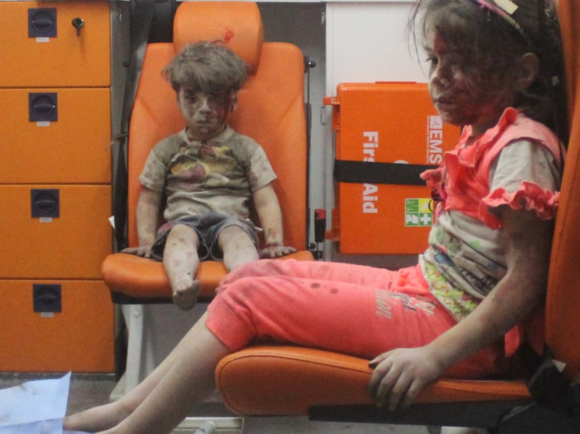 Five-year-old Omran Daqneesh, with bloodied face, sits with his sister inside an ambulance after they were rescued following an airstrike in the rebel-held al-Qaterji neighbourhood of Aleppo, Syria. Photo: Reuters