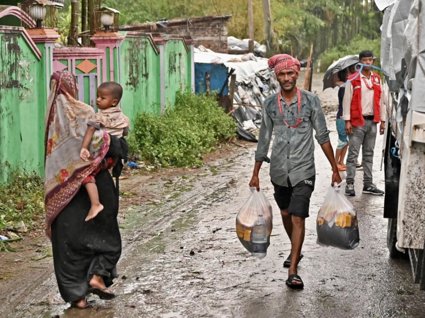 A member of the Red Crescent Society carries relief material in Teknaf, Bangladesh on May 14, 2023, after cyclone Mocha's landfall. A member of the Red Crescent Society carries relief material in Teknaf, Bangladesh on May 14, 2023, after cyclone Mocha's landfall.