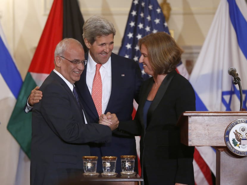 Secretary of State John Kerry stands between Israel's Justice Minister and chief negotiator Tzipi Livni, right, and Palestinian chief negotiator Saeb Erekat, as they shake hands after the resumption of Israeli-Palestinian peace talks, Tuesday, July 30, 2013, at the State Department in Washington. Photo: AP