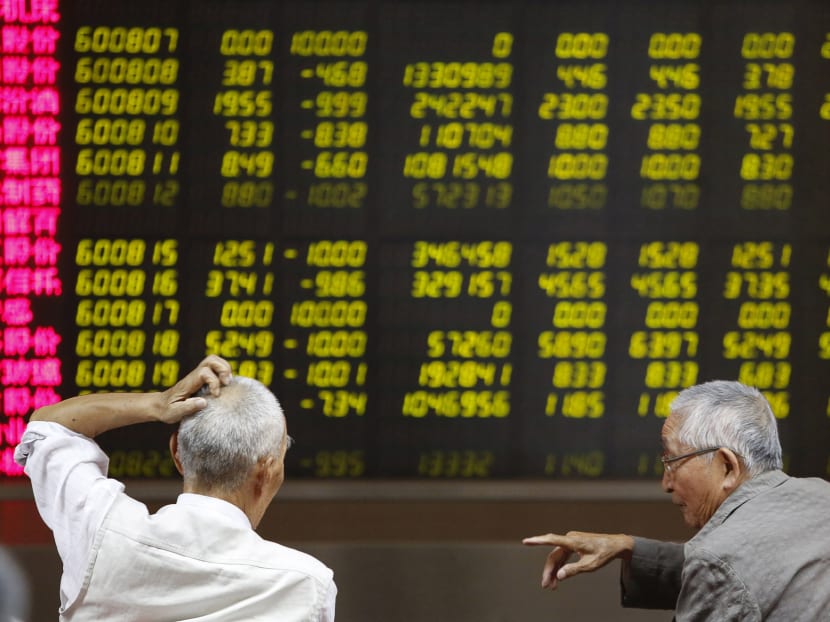 Investors chat as they watch a board showing stock prices at a brokerage office in Beijing. Photo: Reuters