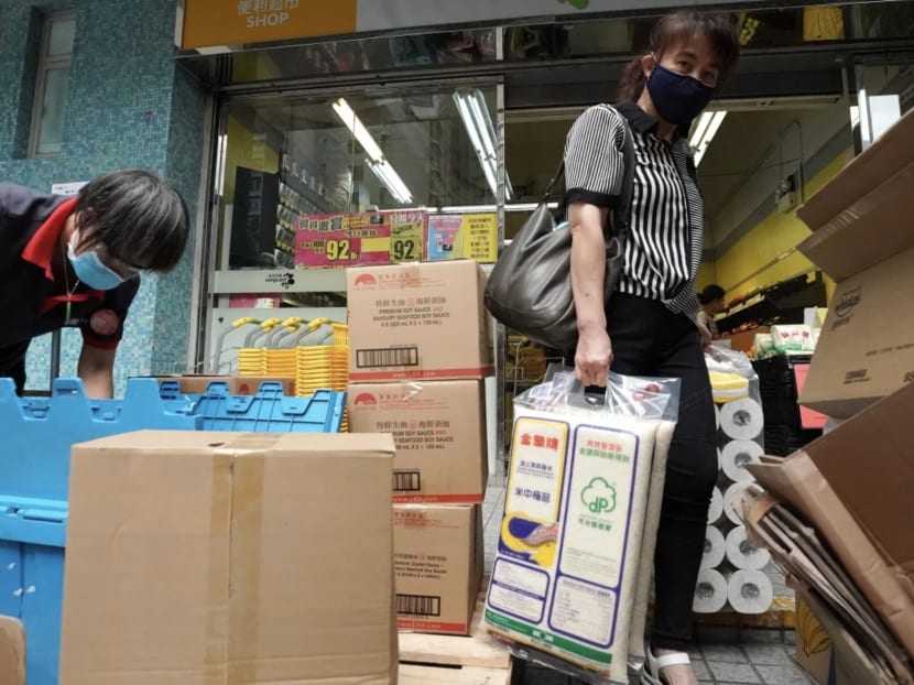 A woman walks out of a supermarket in Tsz Wan Shan on Tuesday with bags of rice and toilet rolls. A woman walks out of a supermarket in Tsz Wan Shan on Tuesday with bags of rice and toilet rolls.