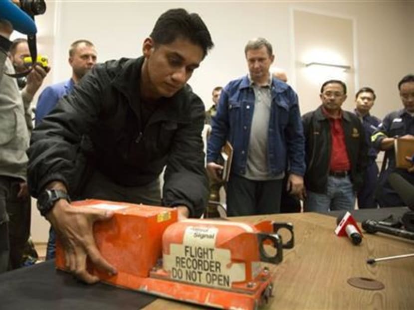 A Malaysian investigator takes a black box from Malaysia Airlines Flight 17 as it is handed over from Donetsk People's Republic officials to Malaysian representatives in the city of Donetsk, eastern Ukraine, July 22, 2014. Photo: AP