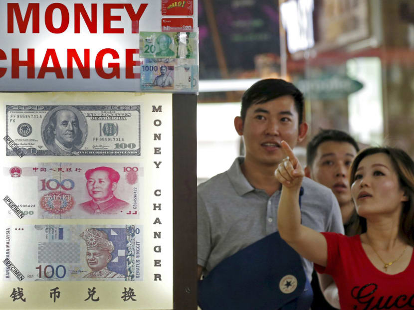 People look at the exchange rate at a moneychanger. Reuters file photo