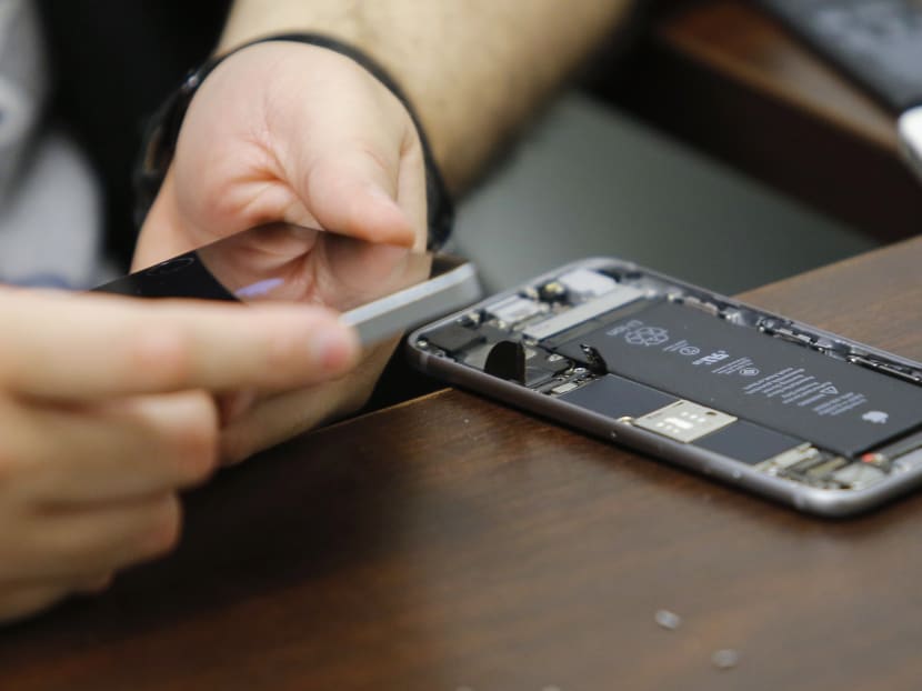 A worker checks an iPhone in a repair store in New York, in this file photo taken February 17, 2016. Photo: Reuters