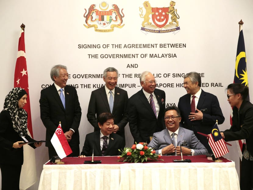 Singapore's PM Lee Hsien Loong and Malaysia's PM Najib Razak witness the signing of the Kuala Lumpur-Singapore High Speed Rail agreement in Putrajaya on Dec 13, 2016. Photo: Jason Quah