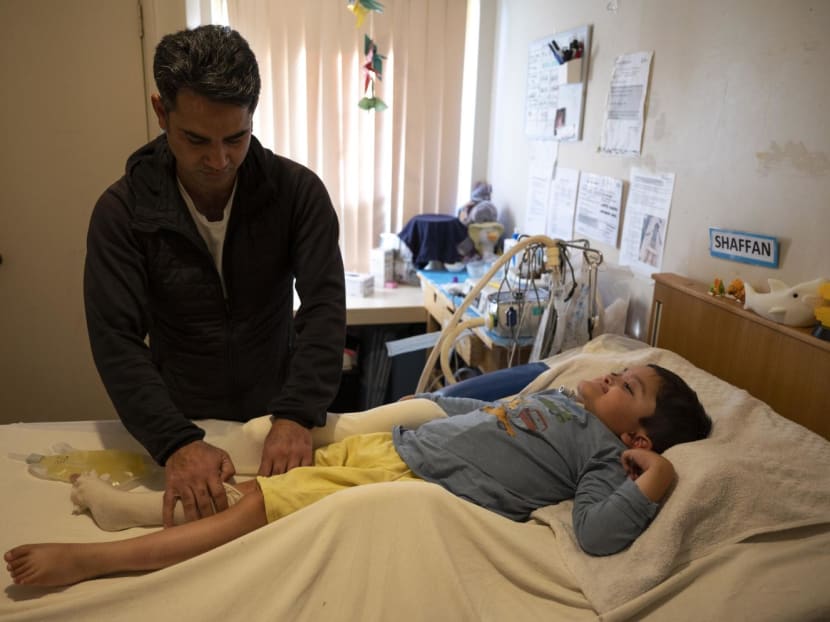 Shaffan Muhammad Ghulam, who has born in Perth, Australia, to Pakistani parents and who has a genetic condition that has left him paralysed, at home with his father, Mr Qasim Butt, in Murdoch, a suburb of Perth, Australia on June 24, 2022. 