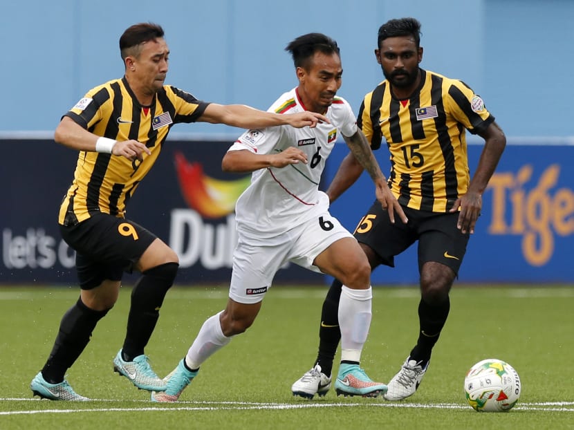 Myanmar's Yan Aung Kyaw (centre) takes the ball past Malaysia's Norshahrul Idlan Talaha and Gary Steven Robbat (right) during their AFF Suzuki Cup Group B soccer match in Singapore, Nov 23, 2014. Photo: AP