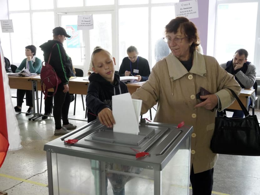 A woman casts her ballot for a referendum at a polling station in Mariupol on Sept 27, 2022. A woman casts her ballot for a referendum at a polling station in Mariupol on Sept 27, 2022.