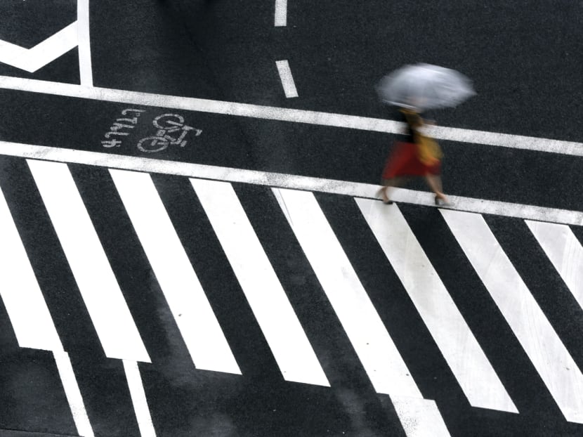 A woman walks on a pedestrian crossing in the rain Wednesday, June 21, 2017, in Tokyo. Photo: AP