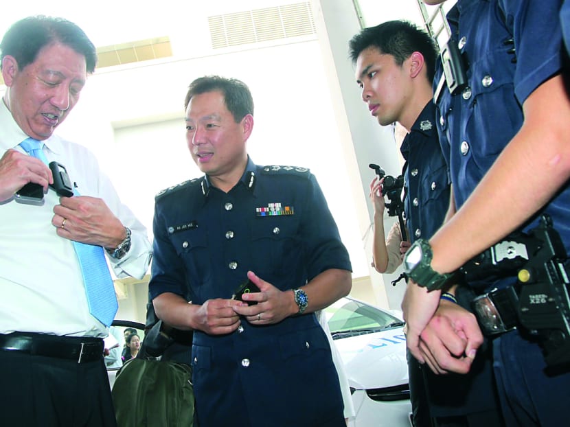 Deputy Prime Minister Teo Chee Hean trying out the body-worn camera with police commissioner Ng Joo Hee. 
Photo: Don Wong