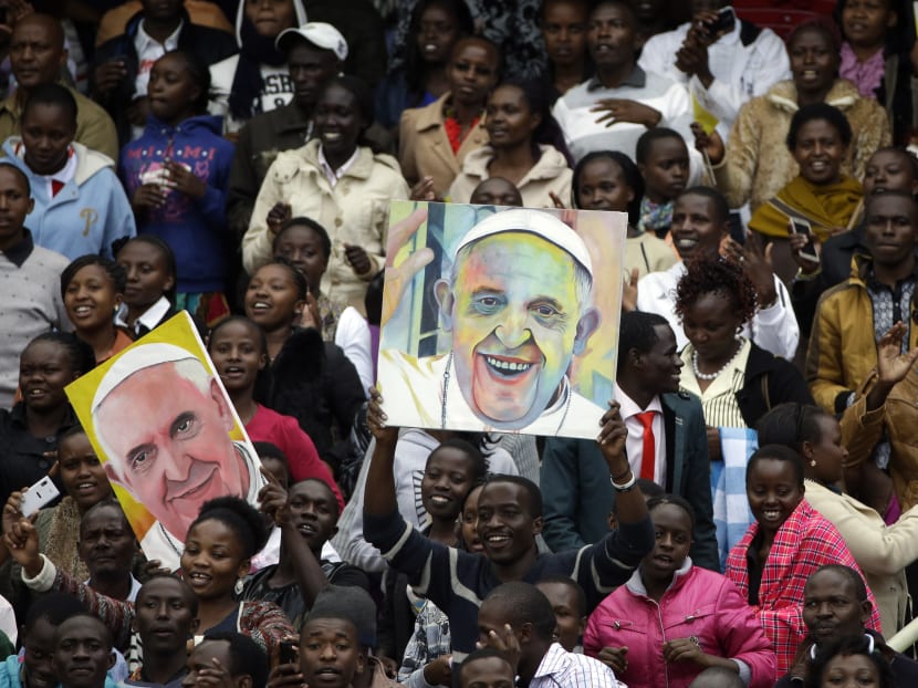 Youths hold images of Pope Francis prior to his arrival for a meeting at Kasarani Stadium, in Nairobi, Kenya, Friday, Nov. 27, 2015. Photo: AP