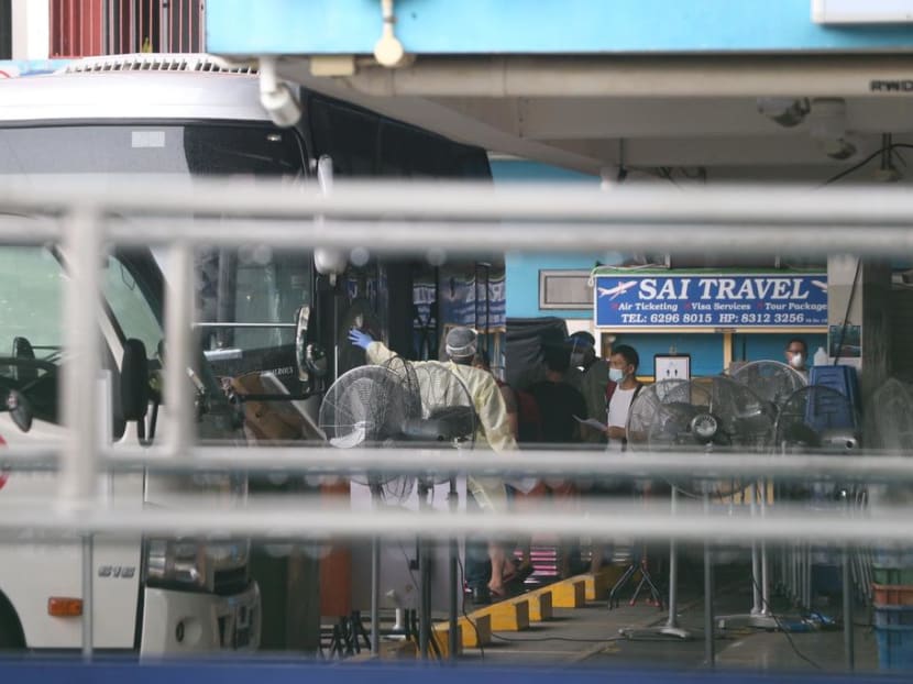 Foreign workers staying at Westlite Woodlands dormitory boarding a bus that will transport them to a government quarantine facility on April 22, 2021.
