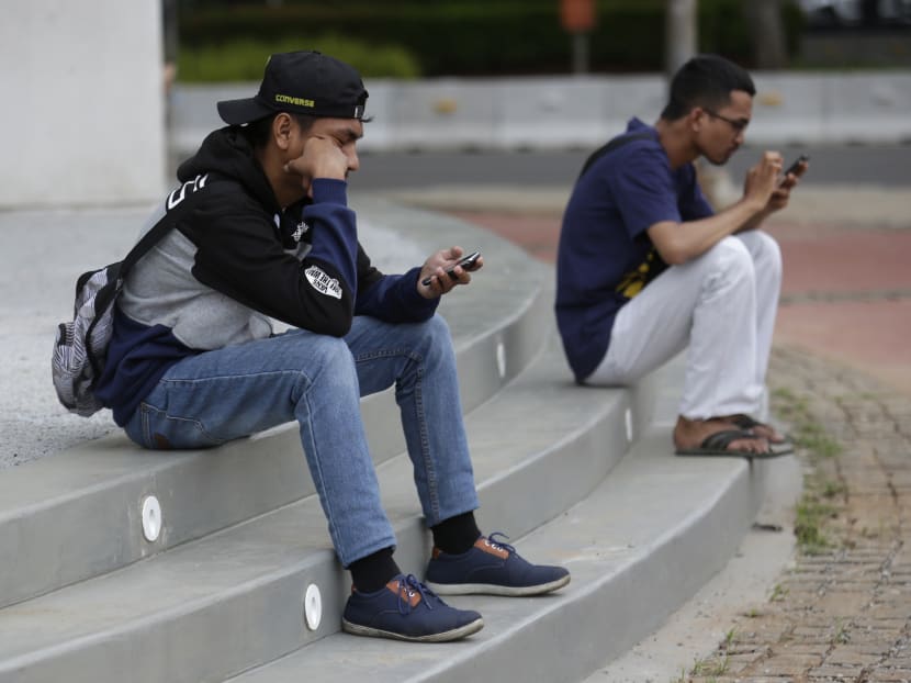 Indonesians gaze at their phones as they play Pokemon Go in Jakarta, Indonesia, on Monday, July 18, 2016. The hugely popular game has sparked a frenzy among Indonesian players despite the application is not officially available in the country. Photo: AP