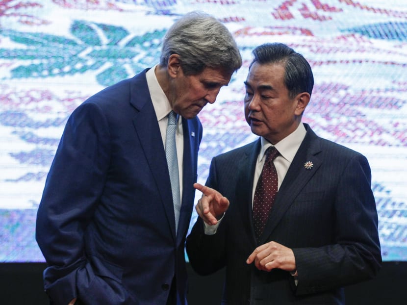 US Secretary of State John Kerry (left) and Chinese Foreign Minister Wang Yi, chat after the group photo session before the East Asia Summit Foreign Ministers' Meeting in Kuala Lumpur, Malaysia on Aug 6. Photo: AP