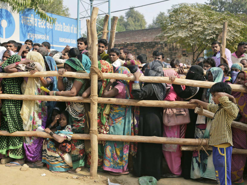 Indians queueing to deposit and exchange discontinued currency notes outside a bank on the outskirts of Allahabad, India, on Nov 17. The abolition of 500-rupee and 1,000-rupee notes has caused frustration as people are forced to stand in long queues at the banks. Photo: AP