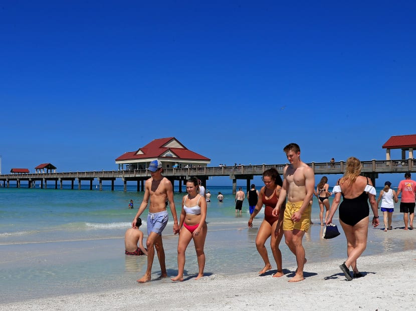 People gather on Clearwater Beach during spring break despite world health officials' warnings to avoid large groups on March 18, 2020 in Clearwater, Florida. The World Health Organization declared Covid-19 a global pandemic on March 11.