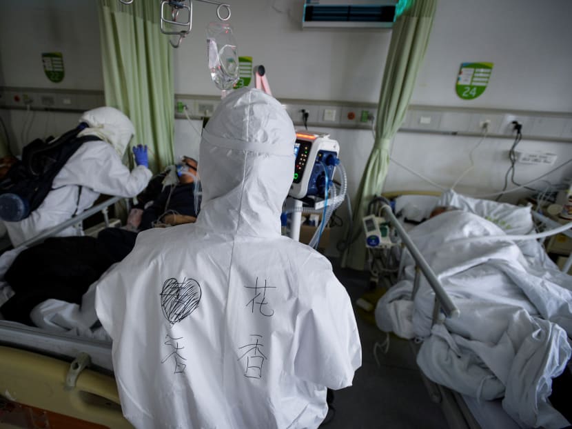 Medical workers in protective suits attend to coronavirus patients inside an isolation ward at a hospital in Wuhan, Hubei province, China, on Feb 6, 2020.