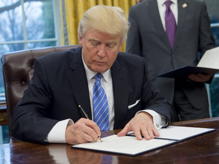 US President Donald Trump signs an executive order withdrawing the US from the Trans-Pacific Partnership in the Oval Office of the White House in Washington, DC, January 23, 2017. Photo: AFP