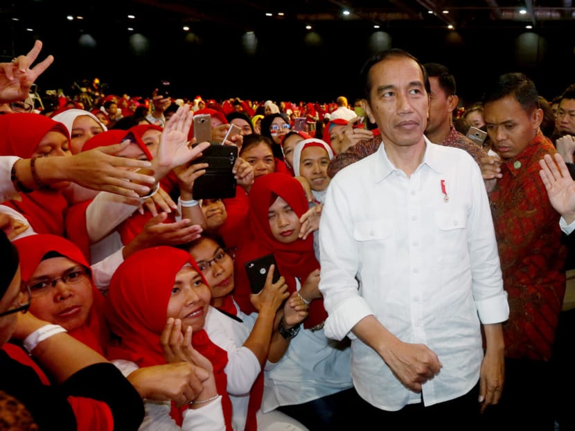 Indonesian President Joko Widodo being greeted by Indonesian migrant workers when he arrived in Hong Kong yesterday. Many of them had called on the President to help ensure better migrant rights for them but Mr Widodo did not address the issue in his speech. Photo: Reuters