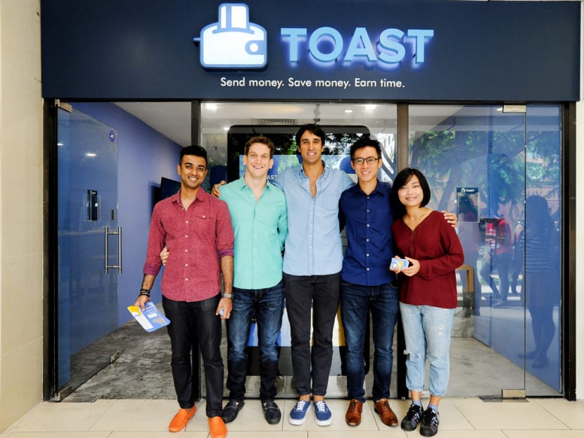 Toast founder and chief executive Aaron Siwoku (centre) with the team in Singapore. Toast will first allow people here to send money via its app to the Philippines and to several other countries by the end of next year. PHOTO: TOAST