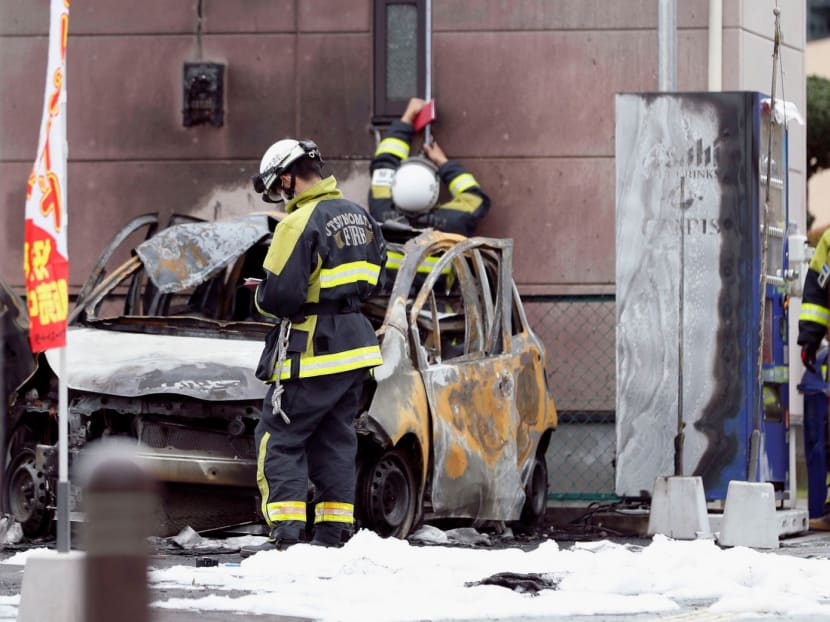 Firefighters investigate a burnt car at the site of an explosion near the park in Utsunomiya, Japan. PHOTO: REUTERS