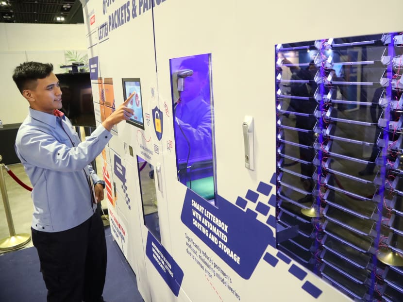 A SingPost worker demonstrating how the smart letterbox system works.