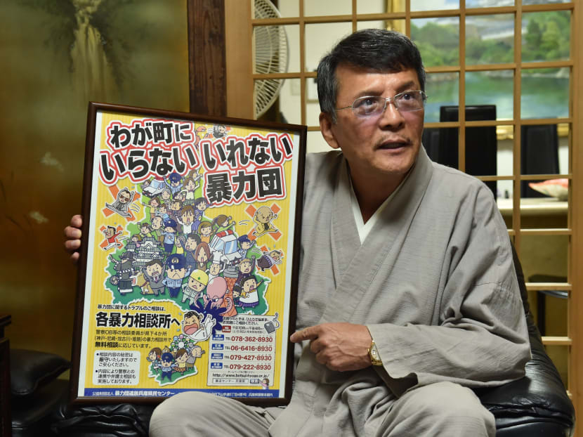 In this 2015 file photo, Satoru Takegaki, 64, a one-time bodyguard for a former Yamaguchi-gumi leader, shows an anti-gang campaign poster during an interview by AFP. Ten years after retiring from a life of crime, Satoru Takegaki now spends his days helping other ex-gangsters find day jobs and adjust to life outside Japan's notorious yakuza mob. Photo: AFP
