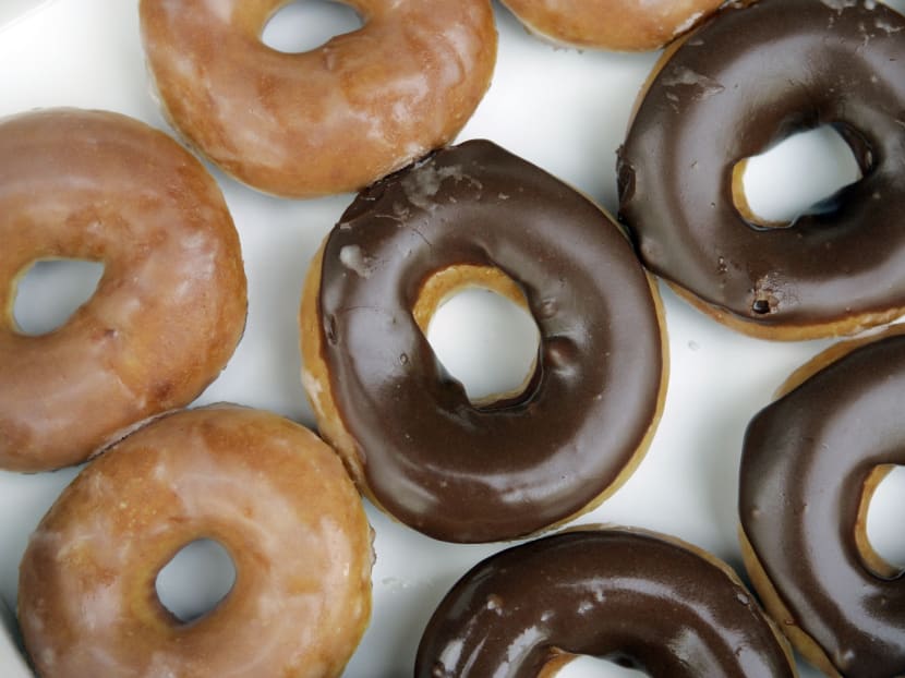 Doughnut chain Krispy Kreme is giving its signature glazed treats a chocolate sheen for the first time ever in honor of the Aug 21 eclipse, where the moon will pass in front of the sun.  Photo: AP