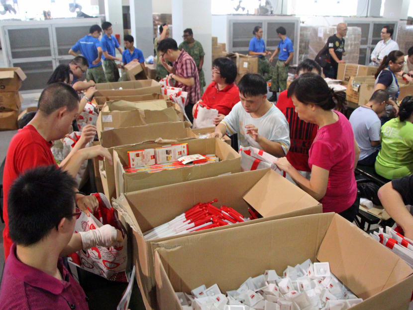 Volunteers from the Down Syndrome Association (DSA) help out in packing SG Funpacks at the Kranji Camp III. Photo: Low Wei Xin