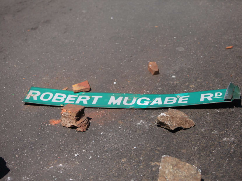 A street sign with President Robert Mugabe's name on it is seen on the ground as Zimbabwe opposition supporters clash with police during a protest march for electoral reforms on Aug 26, 2016 in Harare.
 Photo: AFP