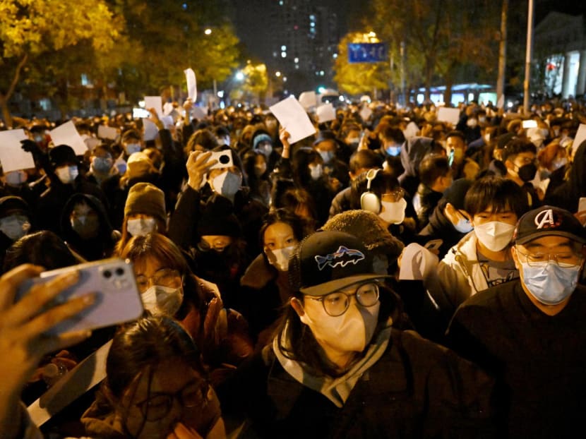 Protesters march along a street during a rally for the victims of a deadly fire as well as a protest against China's harsh Covid-19 restrictions in Beijing on Nov 28, 2022.