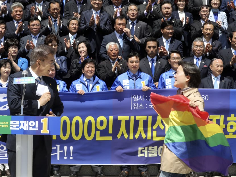 A protestor holding a rainbow flag, approaches South Korea's presidential candidate Moon Jae-in from the Democratic Party, left, against his comment at National Assembly in Seoul, South Korea on April 26, 2017. Photo: Yonhap via AP