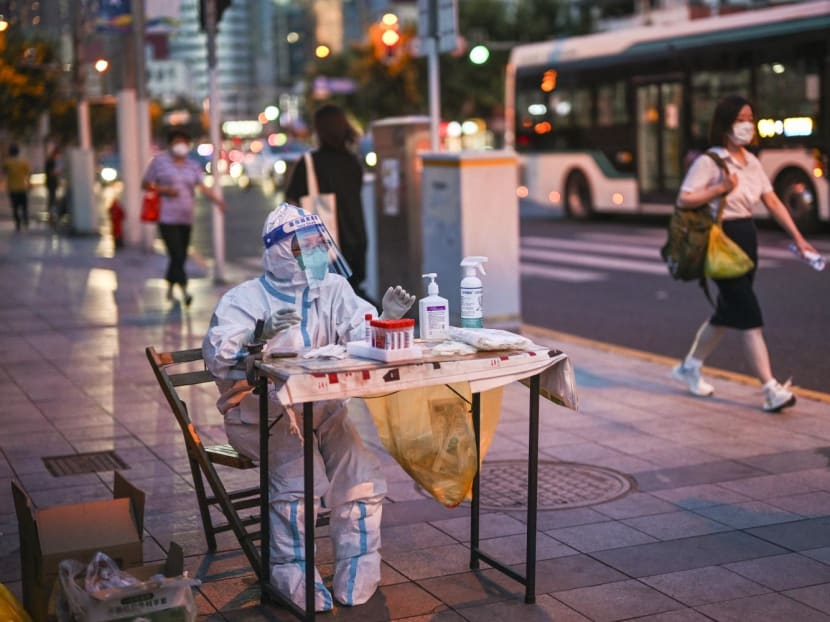 A health worker waits to test people for the Covid-19 coronavirus on a street next to a residential area in the Jing'an district of Shanghai on July 5, 2022. A health worker waits to test people for the Covid-19 coronavirus on a street next to a residential area in the Jing'an district of Shanghai on July 5, 2022.