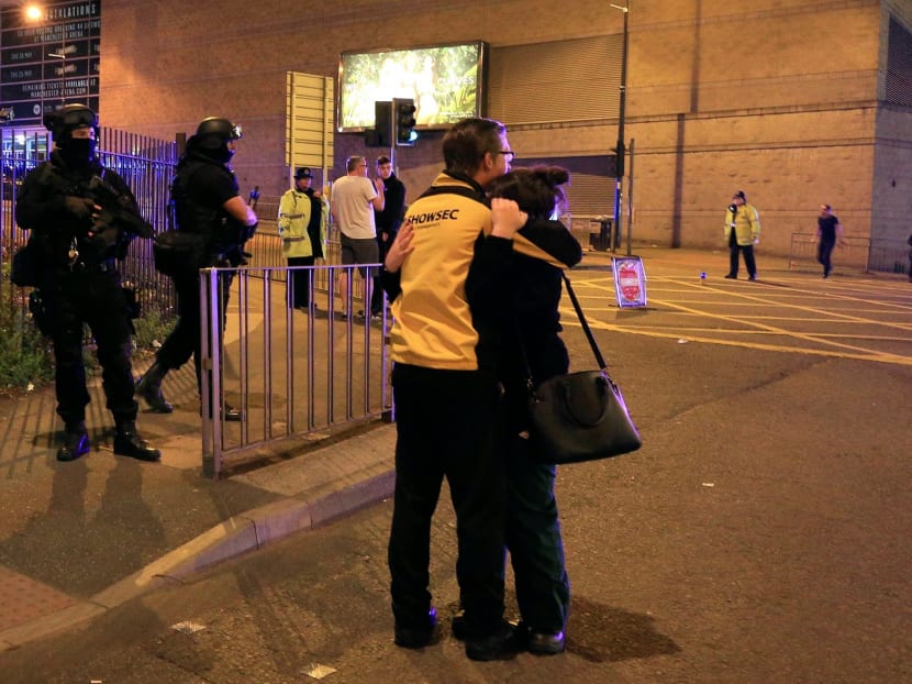 Armed police (left) at Manchester Arena after reports of an explosion at the venue during an Ariana Grande gig. Photo: Peter Byrne/PA Wire via AP