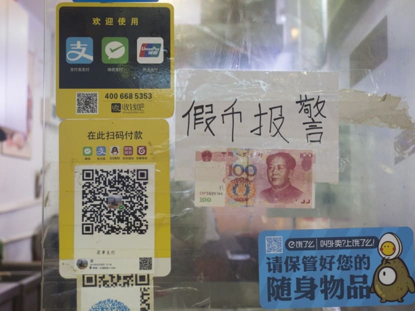 Signs on a shop in Shenzhen’s Dongmen Ding Plaza in August say it accepts mobile payments and warn shoppers not to present fake banknotes. Photo: South China Morning Post