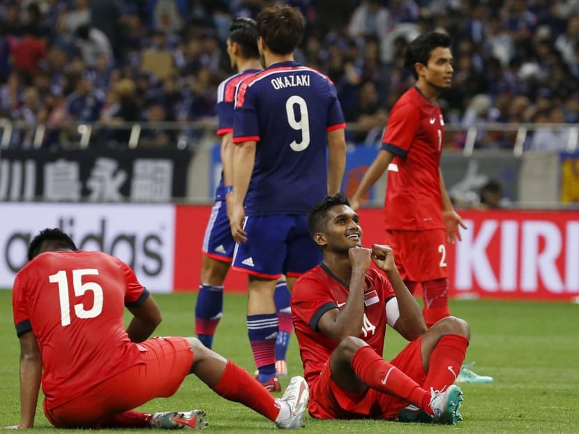 Singapore's Hariss Harun (C, seated) reacts after ending in a scoreless draw against Japan during their 2018 World Cup qualifying soccer match at Saitama Stadium in Saitama, north of Tokyo. Reuters file photo