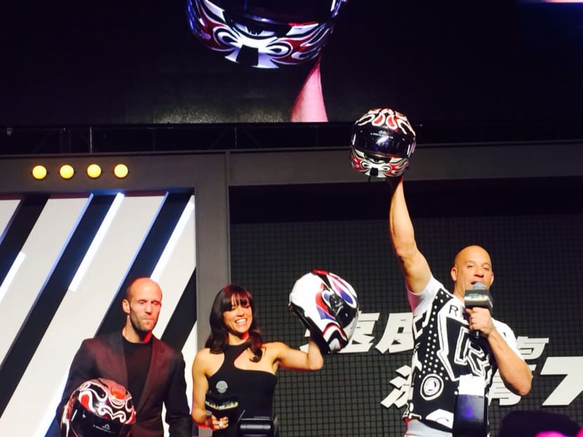 Jason Statham, Michelle Rodrigeuz and Vin Diesel show off their helmets painted to look like Chinese masks at the Fast And Furious 7 press conference in Beijing. Photo: Genevieve Loh