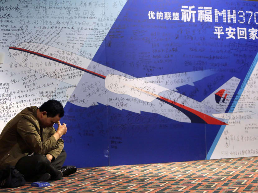 A man, whose younger brother is a passenger onboard Malaysia Airlines Flight MH370, pauses as he smokes next to a message board dedicated to passengers onboard the flight at Lido Hotel in Beijing March 29, 2014.  Photo: Reuters