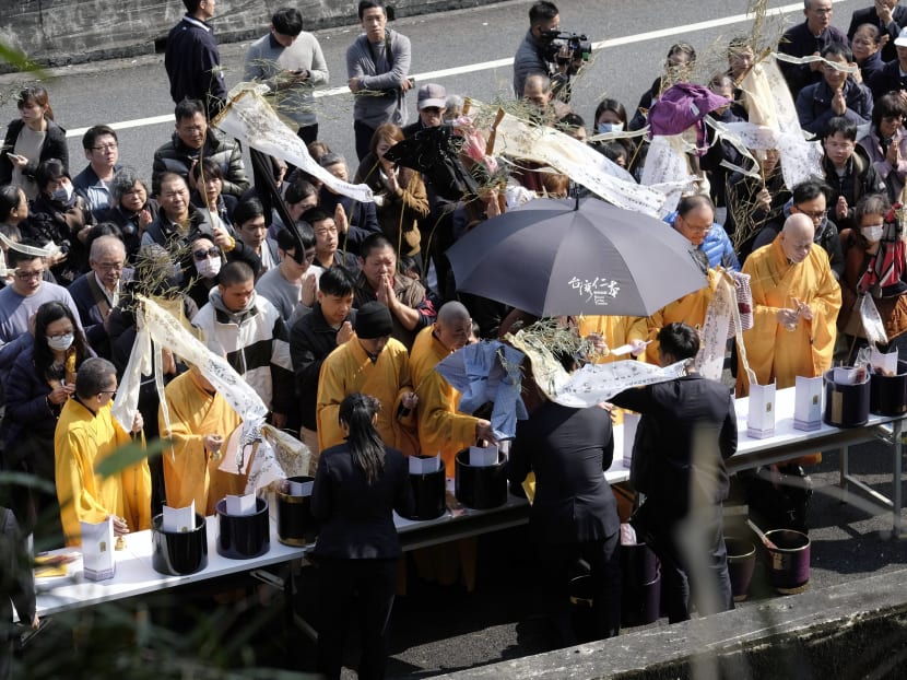 Relatives of victims killed in the bus accident praying during a visit to the crash site in Taipei on Feb 14, 2017. Photo: AFP
