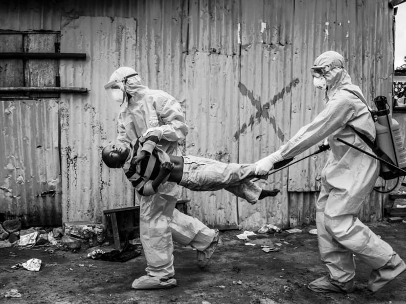 Medical workers taking a child suspected of having Ebola into the JFK treatment centre in Monrovia, Liberia, earlier this year. The disastrous state of healthcare in Liberia and Sierra Leone, where Ebola is raging, reflects decades of horrific civil war in both countries. Photo: The New York Times