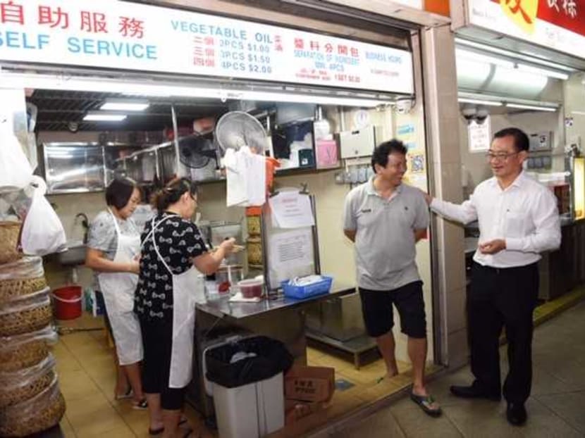 Mr Seah Kian Peng, group chief executive officer of NTUC Enterprise, (right) interacting with one of the hawkers at the Foodfare hawker centre. Mr Seah announced the formation of FairPrice Group on Tuesday (Oct 22).